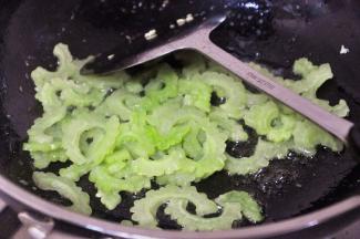将就锅里的油，倒入苦瓜翻炒片刻。