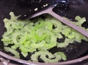 将就锅里的油，倒入苦瓜翻炒片刻。