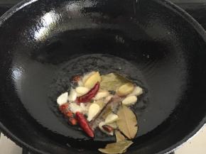 锅内倒入适量油，放入生姜，桂皮，干辣椒，香叶，大蒜炒香