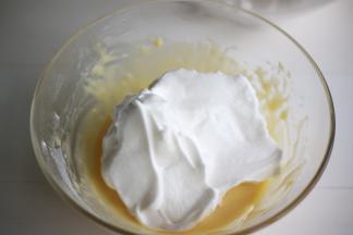 分两次混合蛋白霜与蛋黄糊，先将1/2的蛋白霜加入到蛋黄糊中翻拌均匀