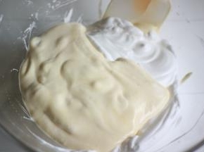 将翻拌均匀的面糊倒回剩余的1/2蛋白霜中