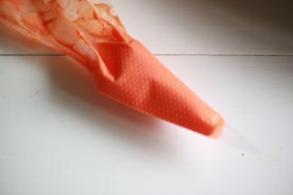 将少许黄油软化，加入橙色色素搅打顺滑画嘴巴