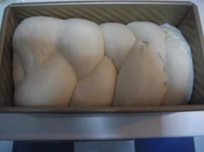 面团发至模具九分满时，将菠萝皮取出，剪开保鲜袋。