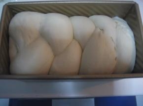 面团发至模具九分满时，将菠萝皮取出，剪开保鲜袋。