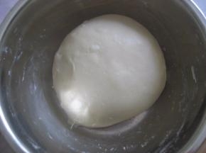 面团材料中除黄油外全部混合均匀，将面团揉至稍具光滑状，加入软化的黄油，继续揉摔至完全阶段（面团能抻出透明的坚韧的薄膜，戳开的洞口呈光滑状，无锯齿）；