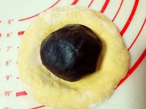 取一小块面团，用手掌心按压成饼，(用擀面杖也可以) 放入豆沙馅，包起来。