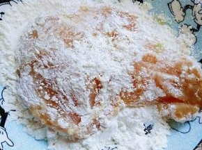 取出腌制好的鸡排，首先在面粉么容器里沾满面粉。