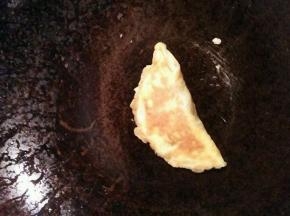 掀起蛋皮的一边盖住肉  然后轻轻用铲子压一下边缘直到完全粘合  然后将两面都稍微煎会就好啦