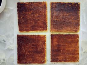 制作糖浆：细砂糖加水和速溶咖啡，煮沸晾凉。将四块蛋糕面上都刷上糖浆