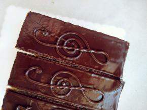 剩的镜面巧克力装入裱花袋，剪小口，表面凝固后画上音符图案，用少许金箔和可食用金粉装饰即可