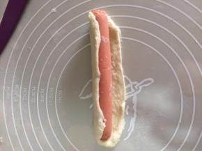 用切割出来的面团分成3份，擀开包住火腿肠