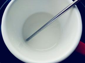 细砂糖加水，倒入小口的搪瓷杯中，小火加热至118度离火，中途不要搅动。不粘杯壁能避免糖水反砂，用电陶炉加热比电磁炉均匀，操作时不要开吸油烟机，会使表面空气流动过快，温度不一致会反砂