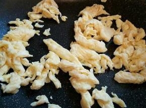 鸡蛋加盐，料酒打散，锅里放一点点底油，把鸡蛋液倒下去，用筷子划散