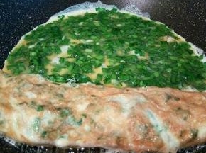 等到鸡蛋液表面定型，给它卷起来，放到旁边一点，然后再倒入2勺蛋液，