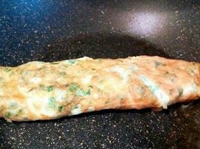 等蛋液表面凝固，再卷起来，开中火煎熟就可以。