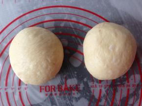 面团发酵好后取出按压排气，分成两等份。滚圆，盖上保鲜膜，松驰25分钟。