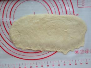 用擀面杖擀平面团，长边擀薄