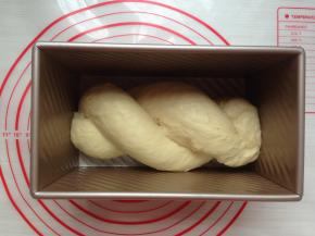 两条面团用交叉的方式造型，两头捏紧，放进法焙客的450克吐司盒