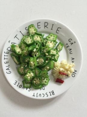 焯水后的秋葵切成小段儿，蒜瓣剁碎，干辣椒切段备用！

