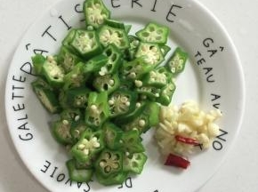 焯水后的秋葵切成小段儿，蒜瓣剁碎，干辣椒切段备用！

