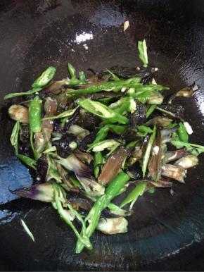 放入茄子蒂和尖椒翻炒均匀！

