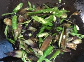 放入茄子蒂和尖椒翻炒均匀！

