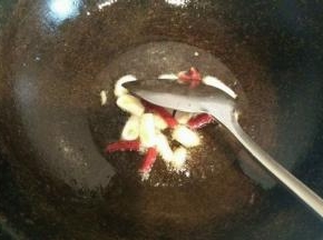 锅内放适量油 油烧热冒烟后 放入大蒜和干辣椒  花椒煸炒出香味