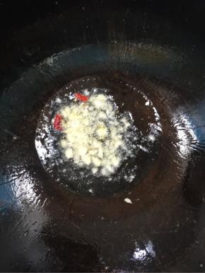 锅中再倒入适量的油，放入蒜瓣，干辣椒爆香！

