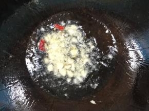 锅中再倒入适量的油，放入蒜瓣，干辣椒爆香！

