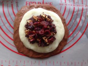 在麻薯团上面放入35克的豆沙馅，再放入蔓越莓干和核桃仁各10克。