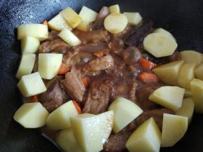 将洗净去皮的土豆和胡萝卜放入，小火焖一会儿