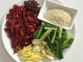 腌制鸡块的时候我们来准备做辣子所需的配料： 干红辣椒用简单剪成2cm左右长的段儿，蒜瓣剥皮按压一下，生姜削皮切成丝，葱切成段，准备好熟芝麻，花椒！

