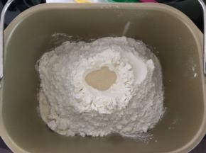 除黄油外所有材料按由湿到干的顺序加入揉面桶，酵母不要和盐同时加入，启动一个揉面程序（23分钟），结束后加入黄油，继续一个揉面程序