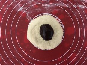 醒发好的面团擀成中间厚周围薄的面饼，包上豆沙馅