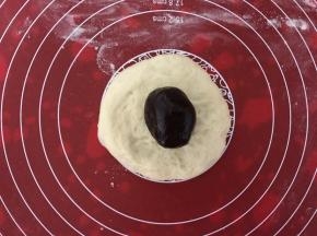 醒发好的面团擀成中间厚周围薄的面饼，包上豆沙馅