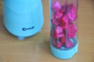 将火龙果切块，倒入果汁杯中。