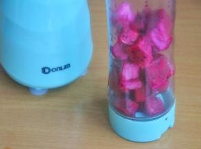 将火龙果切块，倒入果汁杯中。