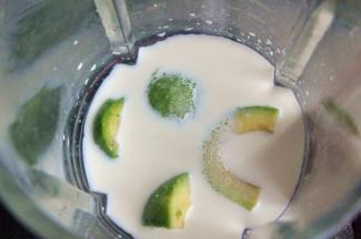 将果肉对切一刀，放入破壁机中，倒入牛奶和白砂糖。