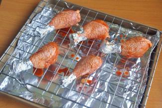 将鸡腿摆在烤网上并用刷子刷上一层腌料，烤盘铺锡纸，烤的时候会有油汁滴落。如果直接滴在烤盘上，烤完烤盘很难清理。