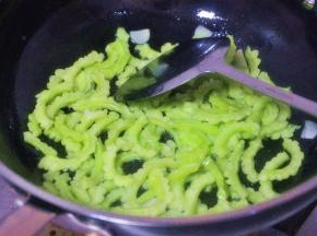 倒入苦瓜中火煸炒至表面微皱颜色金黄，煸炒的过程要有耐心。