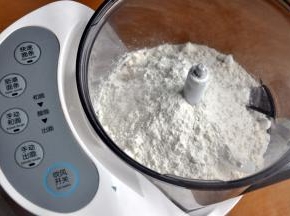 将面粉倒入面条机，盖上盖子，启动快速面条模式。