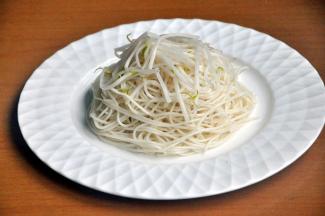 将凉面、豆芽放在盘里。