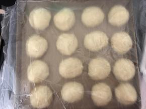 取出发酵好的面团轻压排气，平均分成16份，揉圆，盖上保鲜膜醒发15-20分钟。