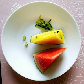 准备好两种颜色的西瓜各一块儿，再准备一块儿西瓜皮，用小模具随便什么花型的都可以，粗一点儿的吸管也是可以的，刻出几个小的配件用来做小鱼吐出的泡泡（我这个只是示范一下，所以只有两个），再用擦菜板擦点绿色的西瓜皮下来。