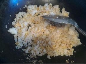 锅内留少许油   倒入鸡蛋液   待鸡蛋液快凝固时倒入米饭炒匀  加入两茶勺盐