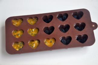 将百香果的果肉挖出来放入冰格，蓝莓也放入冰格，加上适量的水，冷冻冰格。