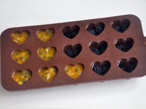 将百香果的果肉挖出来放入冰格，蓝莓也放入冰格，加上适量的水，冷冻冰格。