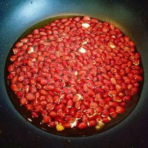 直到花生米外皮有些微微裂开时听到噼咔噼咔的响声就可以出锅了。用捞网捞出花生米，淋一下油，这样吃起来很香酥脆哦。