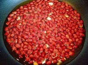 直到花生米外皮有些微微裂开时听到噼咔噼咔的响声就可以出锅了。用捞网捞出花生米，淋一下油，这样吃起来很香酥脆哦。