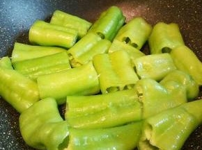 锅里可以放一点点油，把尖椒一个一个放下去铺平，